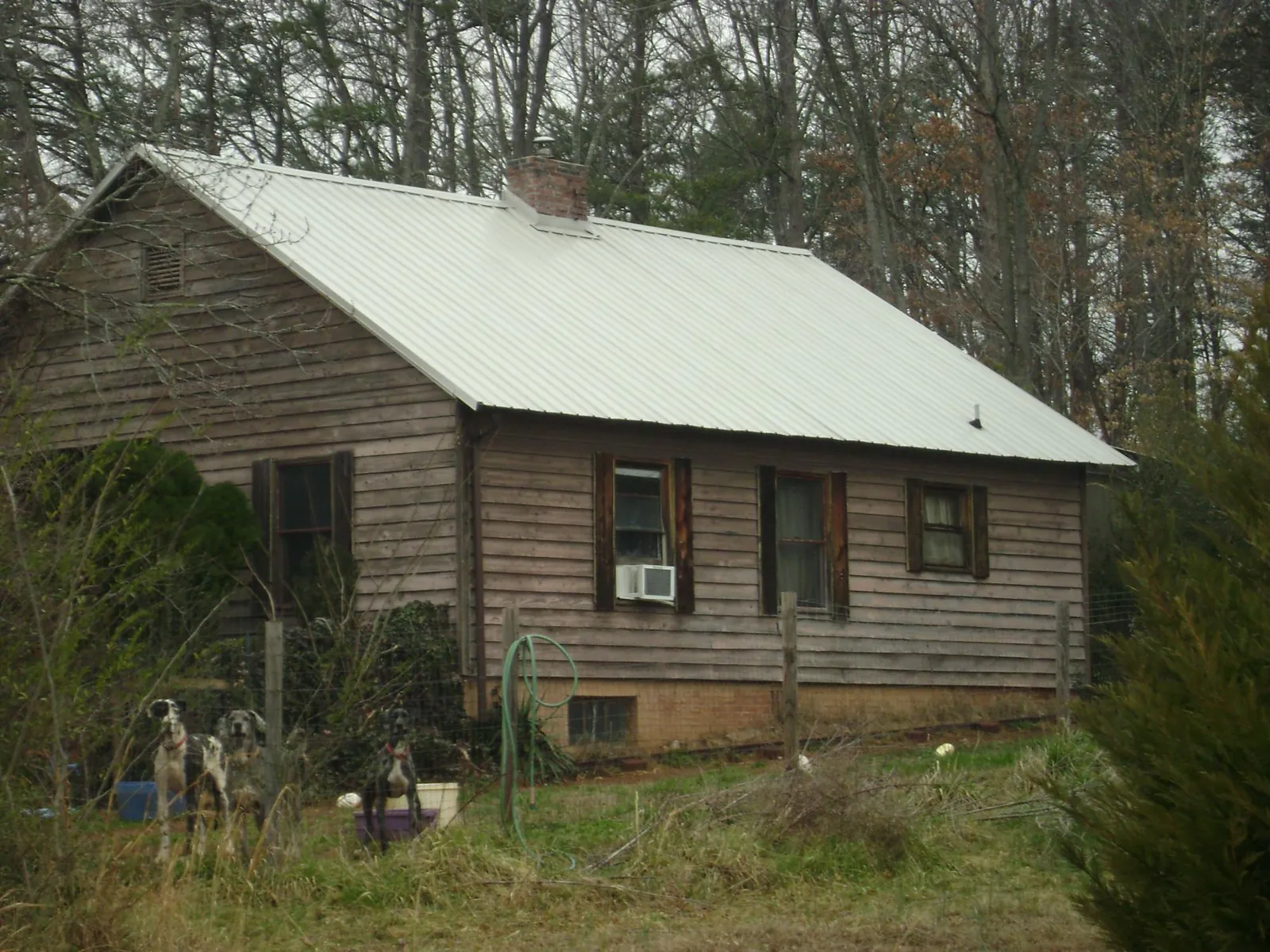 White metal roof on an old wood sided farmhouse, from a Metal Roof Installation job in Roby
